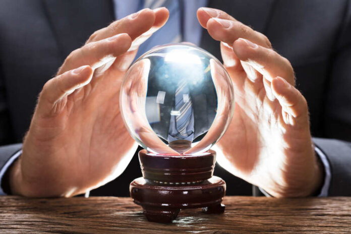 Midsection,Of,Businessman,Covering,Crystal,Ball,At,Wooden,Table